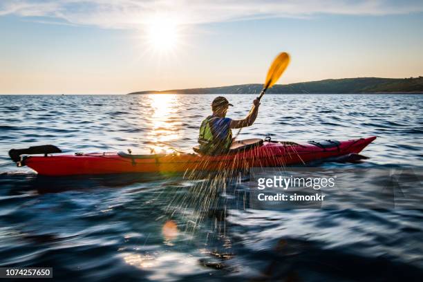 kajakfahrer im meer rudern - kayak stock-fotos und bilder