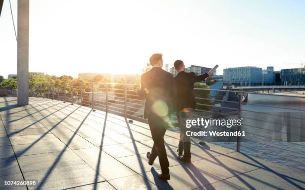 two businessmen walking on a bridge in the city - area 51 stock-fotos und bilder