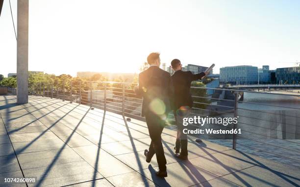 two businessmen walking on a bridge in the city - berlin people ストックフォトと画像