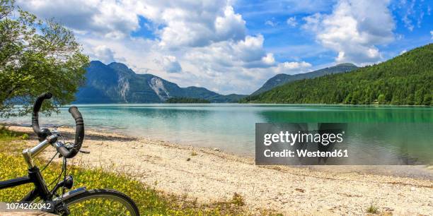 germany, bavaria, lake walchen, bicycle in the foreground - küste stock-fotos und bilder