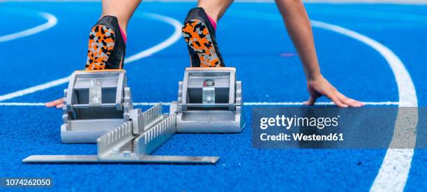 detail of female runner in starting position - starting block photos et images de collection