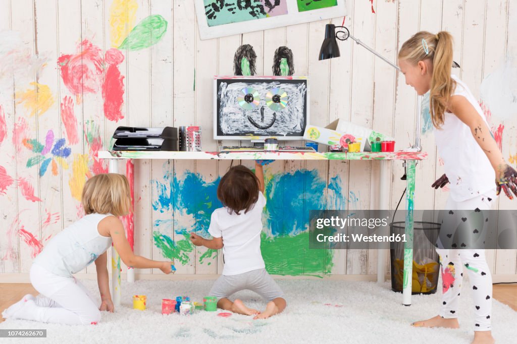 Three girls painting office with finger paint
