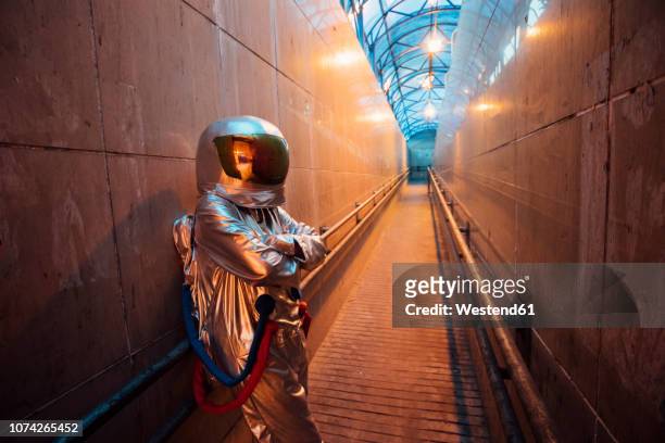 spaceman in the city at night standing in narrow passageway - gray alien stock pictures, royalty-free photos & images