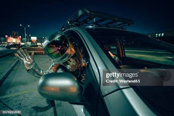 spaceman waving out of car at night - hello future are you there stock pictures, royalty-free photos & images