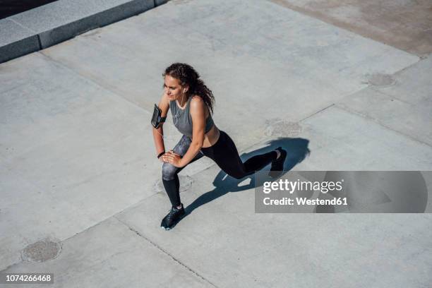 young athletic woman stretching outdoors - leg stretch girl stock-fotos und bilder