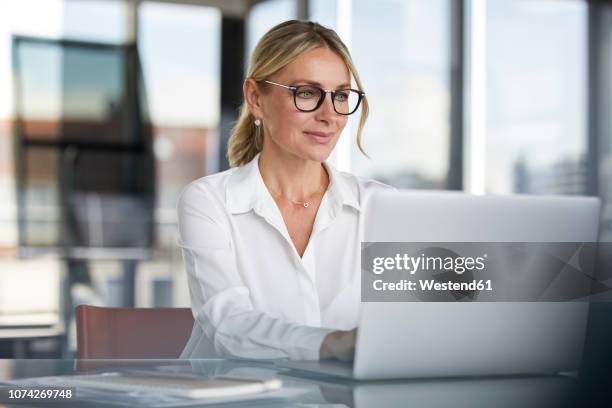 businesswoman working in office, using laptop - woman on computer stock pictures, royalty-free photos & images