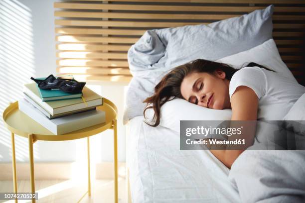 portrait of woman sleeping in bed by daylight - white book stock-fotos und bilder