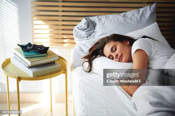 portrait of woman sleeping in bed by daylight - acostado de lado fotografías e imágenes de stock