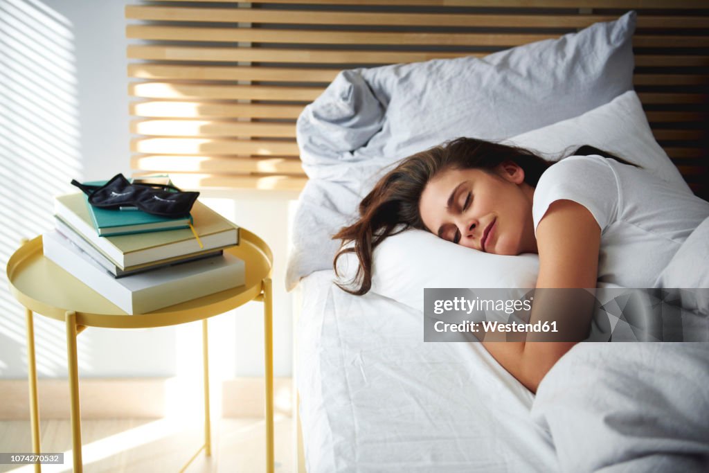 Portrait of woman sleeping in bed by daylight