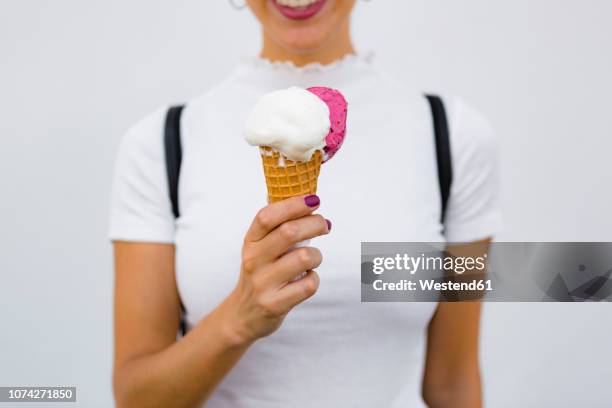 woman's hand holding ice cream cone - frau eistüte stock-fotos und bilder