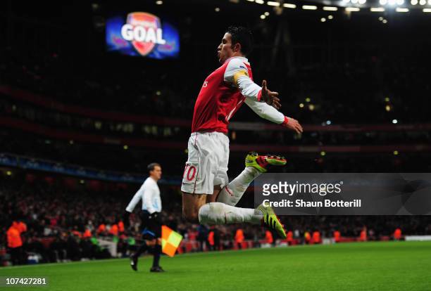 Robin van Persie of Arsenal celebrateds as he scores their first goal from the penalty spot during the UEFA Champions League Group H match between...