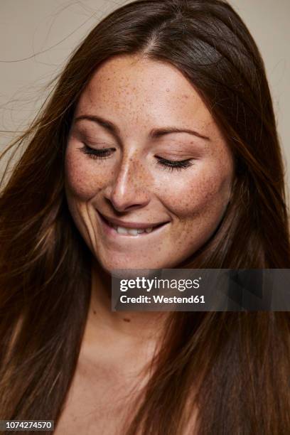 portrait of freckled young woman looking down - face down stock-fotos und bilder