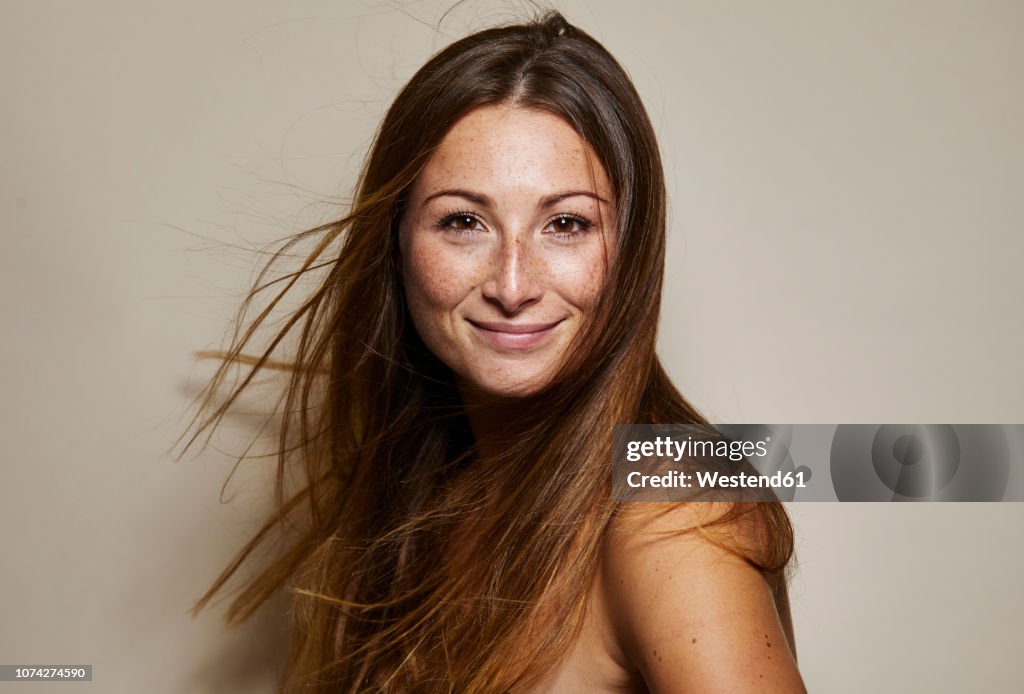 Portrait of freckled young woman with blowing hair