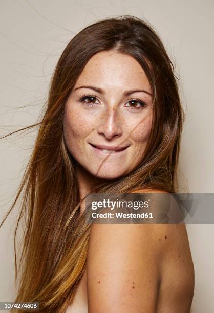 portrait of freckled young woman with blowing hair - off shoulder stock-fotos und bilder