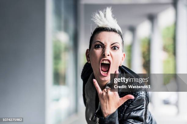 portrait of screaming punk woman at an arcade - capelli alla moicana foto e immagini stock