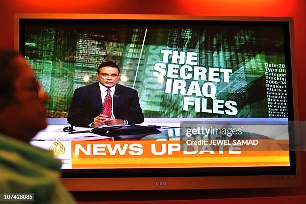 Woman walks past a television set displaying Al Jazeera news channel telecasting news coverage on secret US documents obtained by WikiLeaks, in...