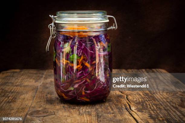 homemade red cabbage, fermented, with chili, carrot and coriander, preserving jar on wood - gären stock-fotos und bilder