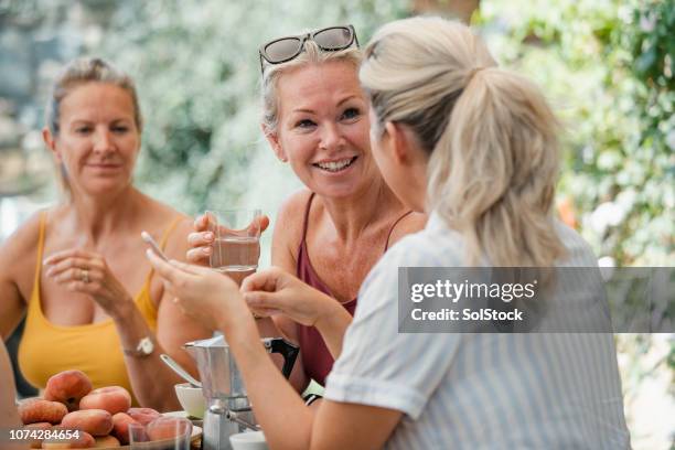 mature women enjoying holiday breakfast - drinking water outside stock pictures, royalty-free photos & images