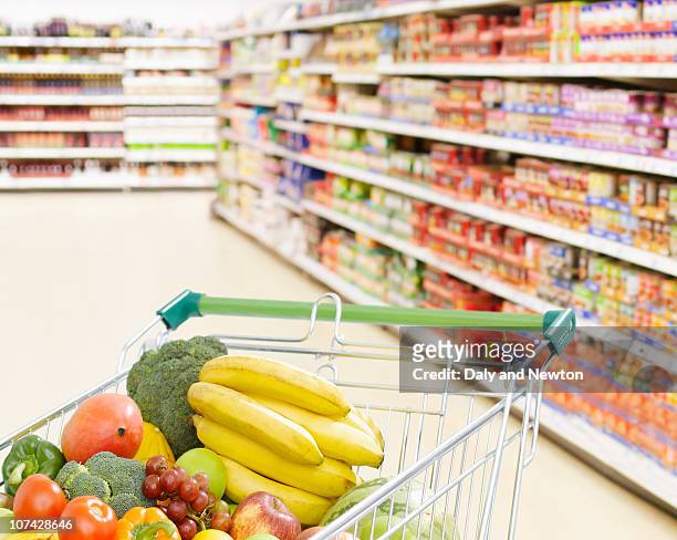 shopping cart in grocery store full of fruits and vegetables - vegetable stock photos et images de collection