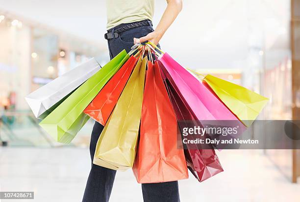 woman carrying shopping bags - boodschappentas tas stockfoto's en -beelden