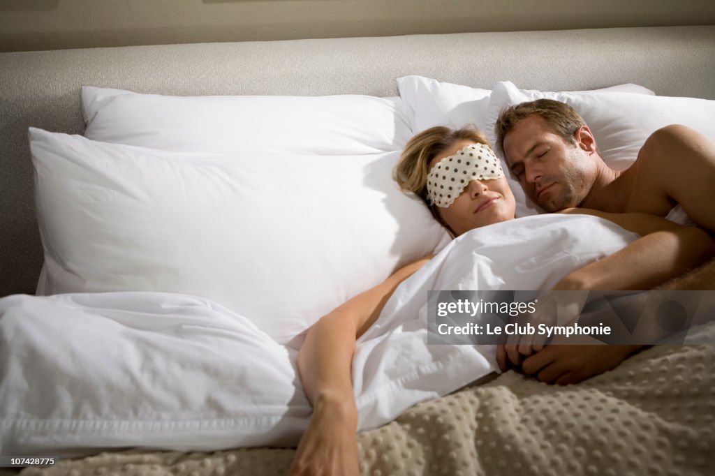 Couple sleeping in bed together