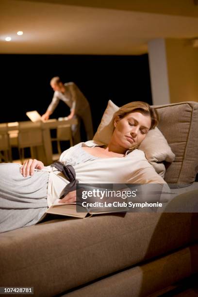 woman sleeping on sofa with husband in background - diva papel humano - fotografias e filmes do acervo