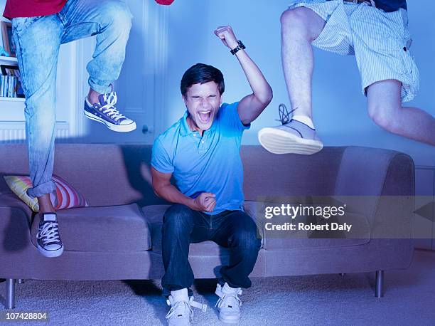 tem amigos na sala de estar a torcer e saltar - tv room side imagens e fotografias de stock