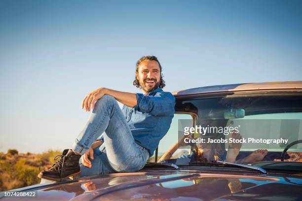 young couple sitting in vintage pick-up truck - landskap stockfoto's en -beelden