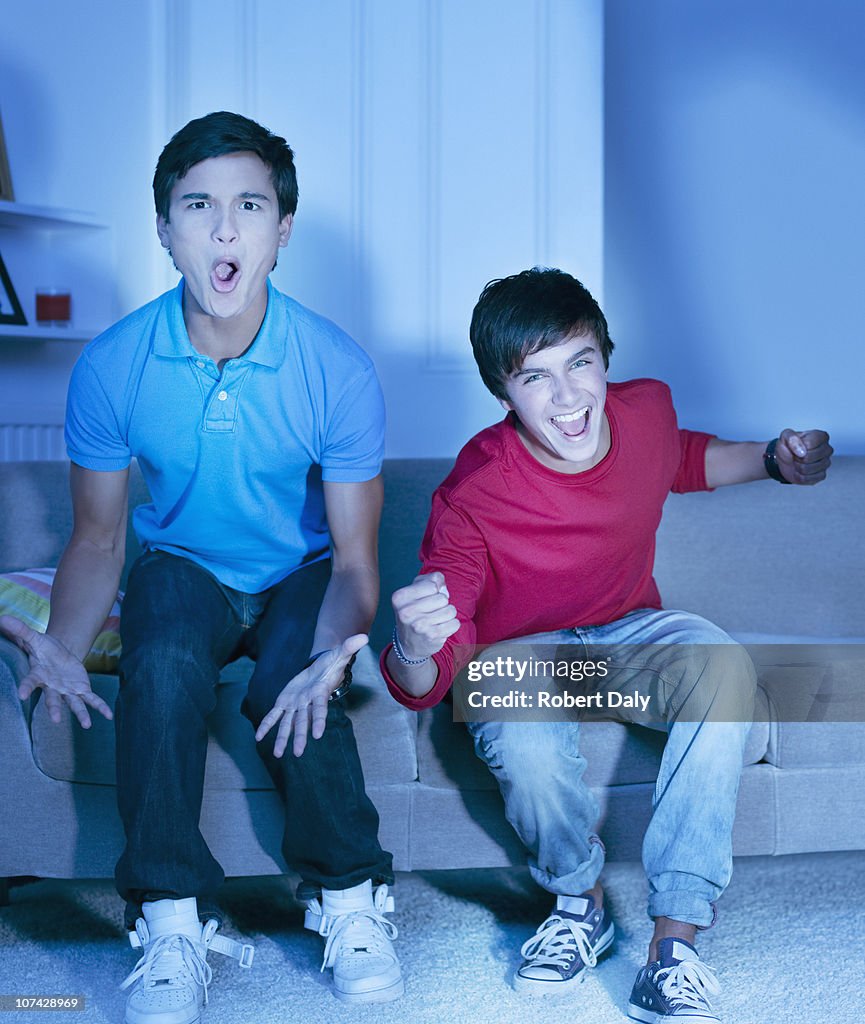 Shouting teenage boys watching television