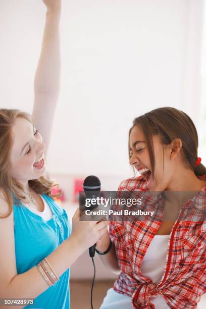 teenage girls singing into microphone - duett bildbanksfoton och bilder