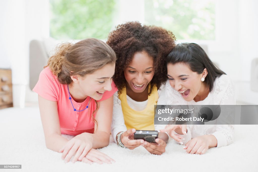 Teenage girls looking at Fotos auf eine digitale Kamera