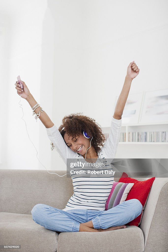 Smiling teenage girl listening to mp3 player