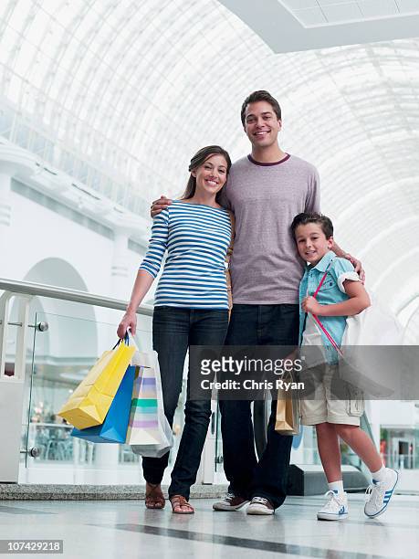 smiling family shopping together in mall - couple shopping in shopping mall stockfoto's en -beelden