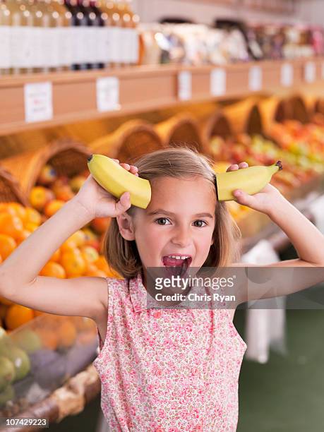 fille tenant banane que horns à l'épicerie - human mouth stock photos et images de collection