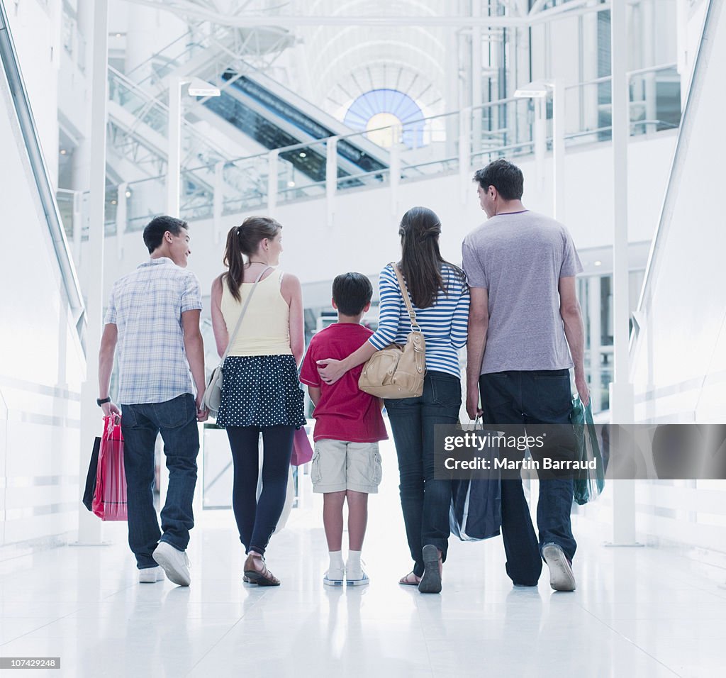 Famille portant des sacs de shopping au centre commercial