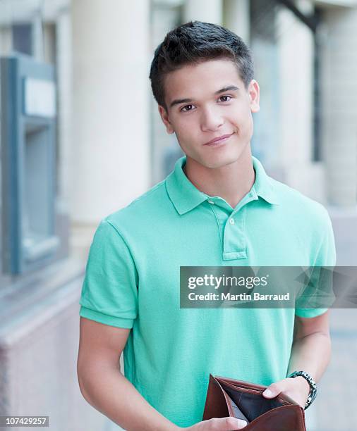 unhappy man holding empty wallet near atm machine - empty wallet stock pictures, royalty-free photos & images