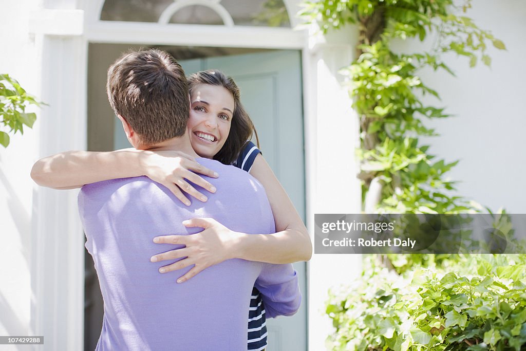 Couple hugging on front stoop