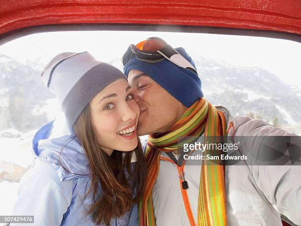 man kissing wife in ski lift - couple ski lift stockfoto's en -beelden