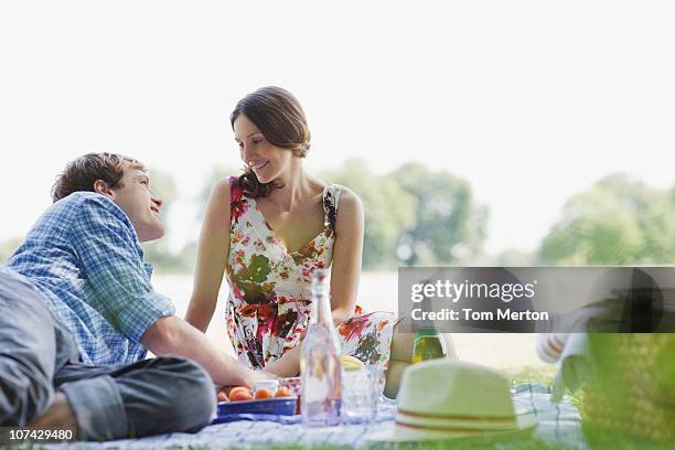 couple having picnic in park - romantic picnic stockfoto's en -beelden