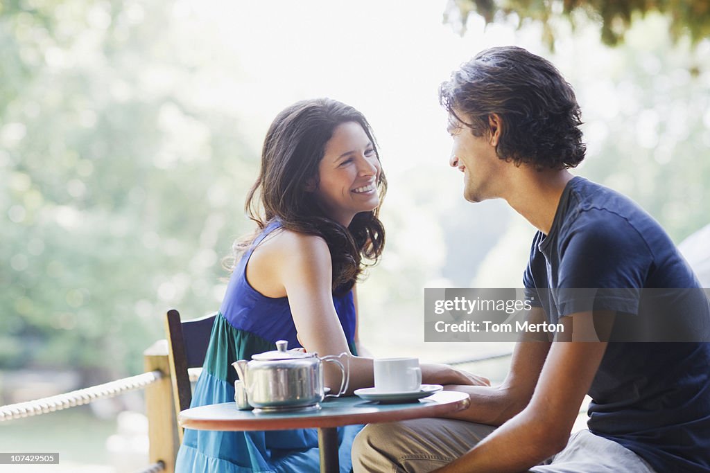 Smiling couple having tea outdoors