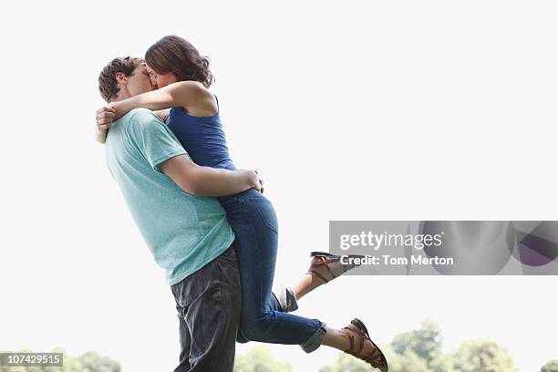 man kissing and lifting wife outdoors - vrouwen 32 jaar samen kus stockfoto's en -beelden