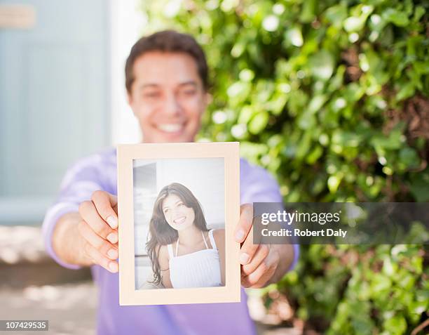 mann hält dir foto von freundinnen - waist up photos stock-fotos und bilder