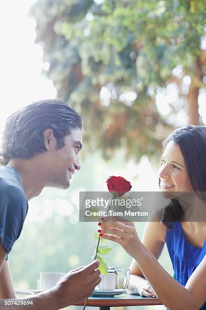 uomo dando fidanzata rosa rossa - single rose foto e immagini stock