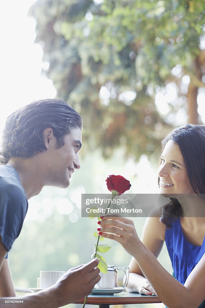 Man giving girlfriend red rose