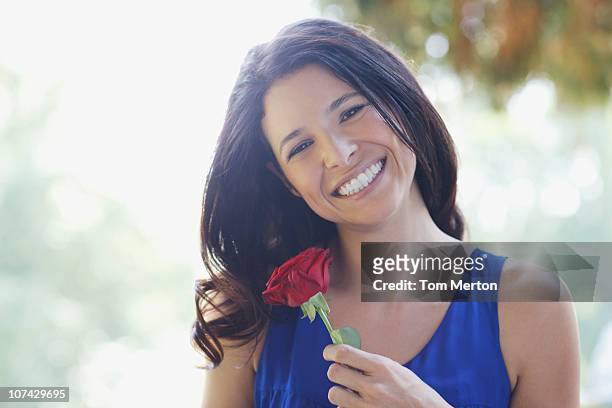 donna sorridente con rosa rossa - single rose foto e immagini stock
