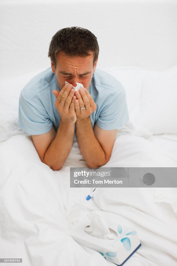 Kranken Mann im Bett Schnäuzen