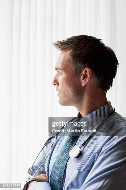 doctor thinking in doctors office - doctor profile view stock pictures, royalty-free photos & images