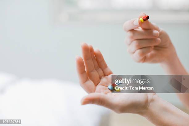 mujer tomando vitaminas y suplementos - medicamentos fotografías e imágenes de stock