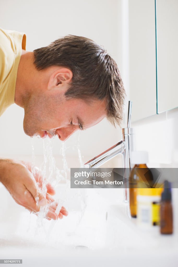 Man washing face in sink