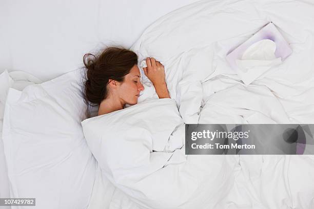 sick woman sleeping in bed - tissue box stockfoto's en -beelden